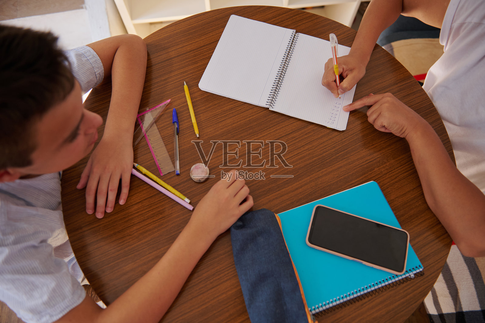 两名学生在圆桌上合作完成作业项目照片摄影图片