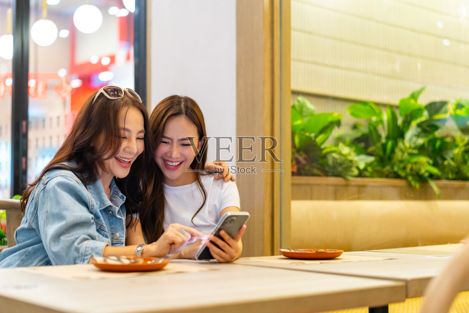 亚洲母女一起使用智能手机。照片摄影图片