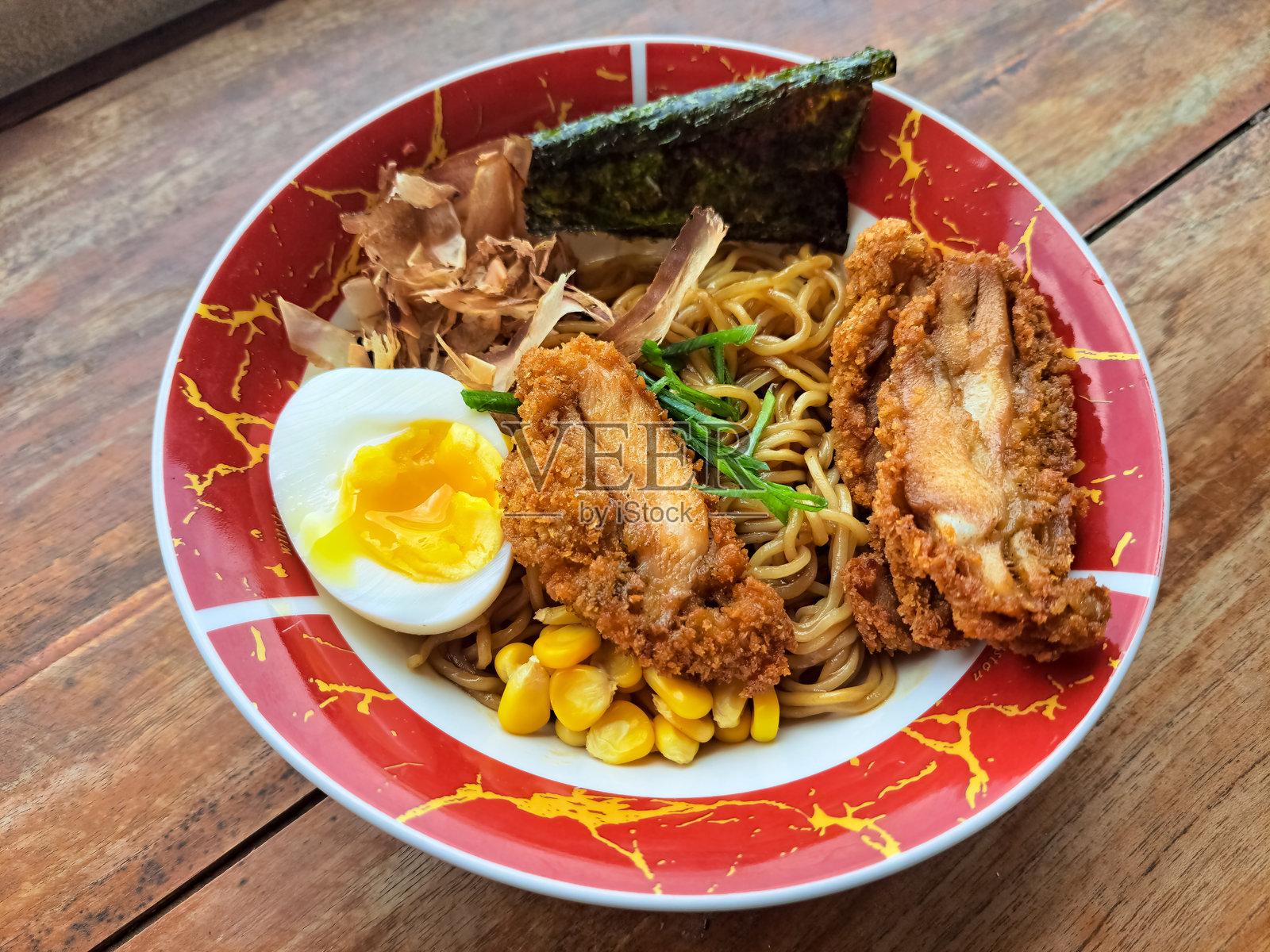 炸干拉面配鸡肉、煮蛋、玉米、葱花、鲣鱼 flakes 和海苔。日本料理菜单。照片摄影图片