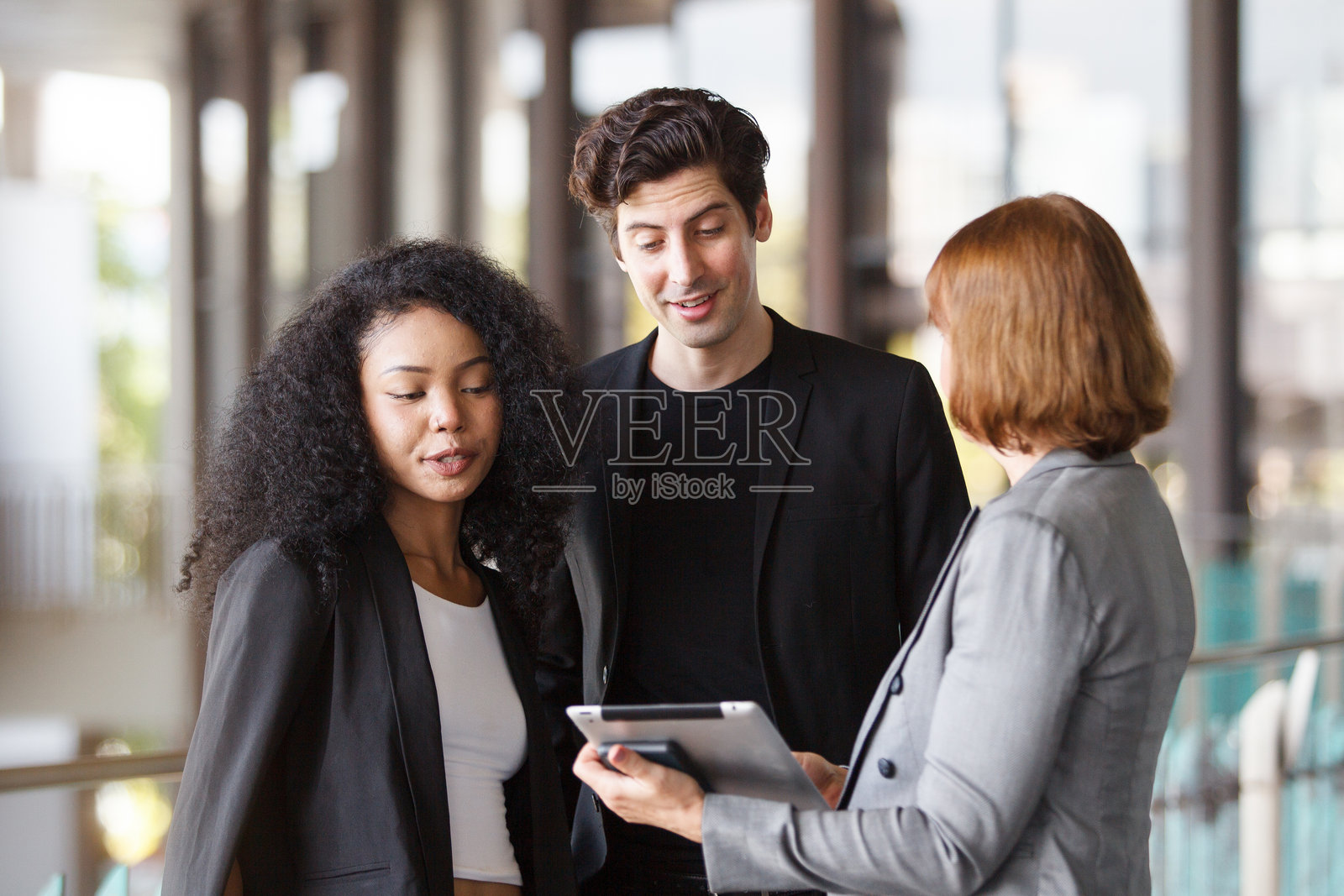 一群商务人士在大楼内交谈。照片摄影图片