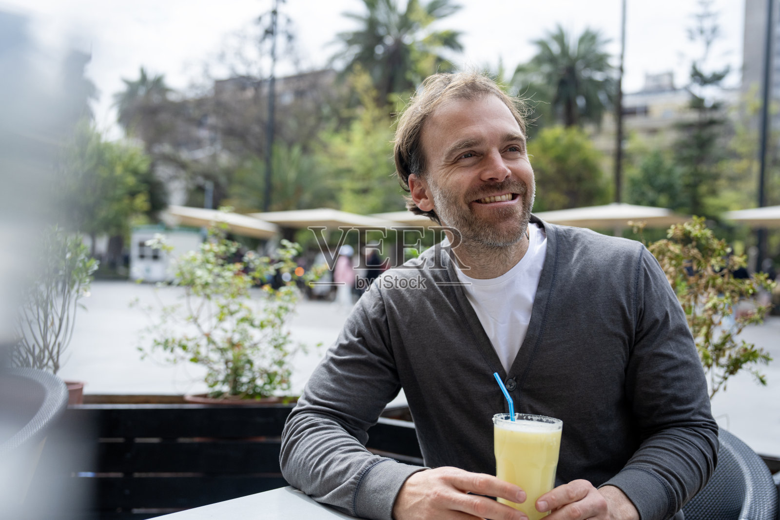 在智利圣地亚哥阿尔马斯广场的人行道咖啡馆里,愉快的游客正在喝饮料。照片摄影图片