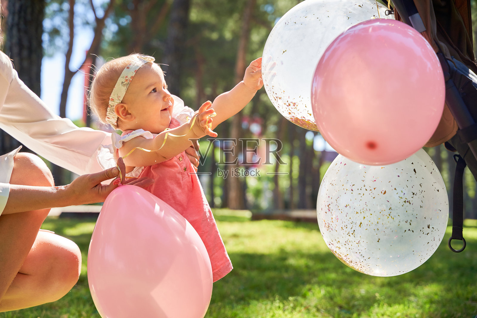 小女孩在生日庆祝活动中伸手去抓气球照片摄影图片
