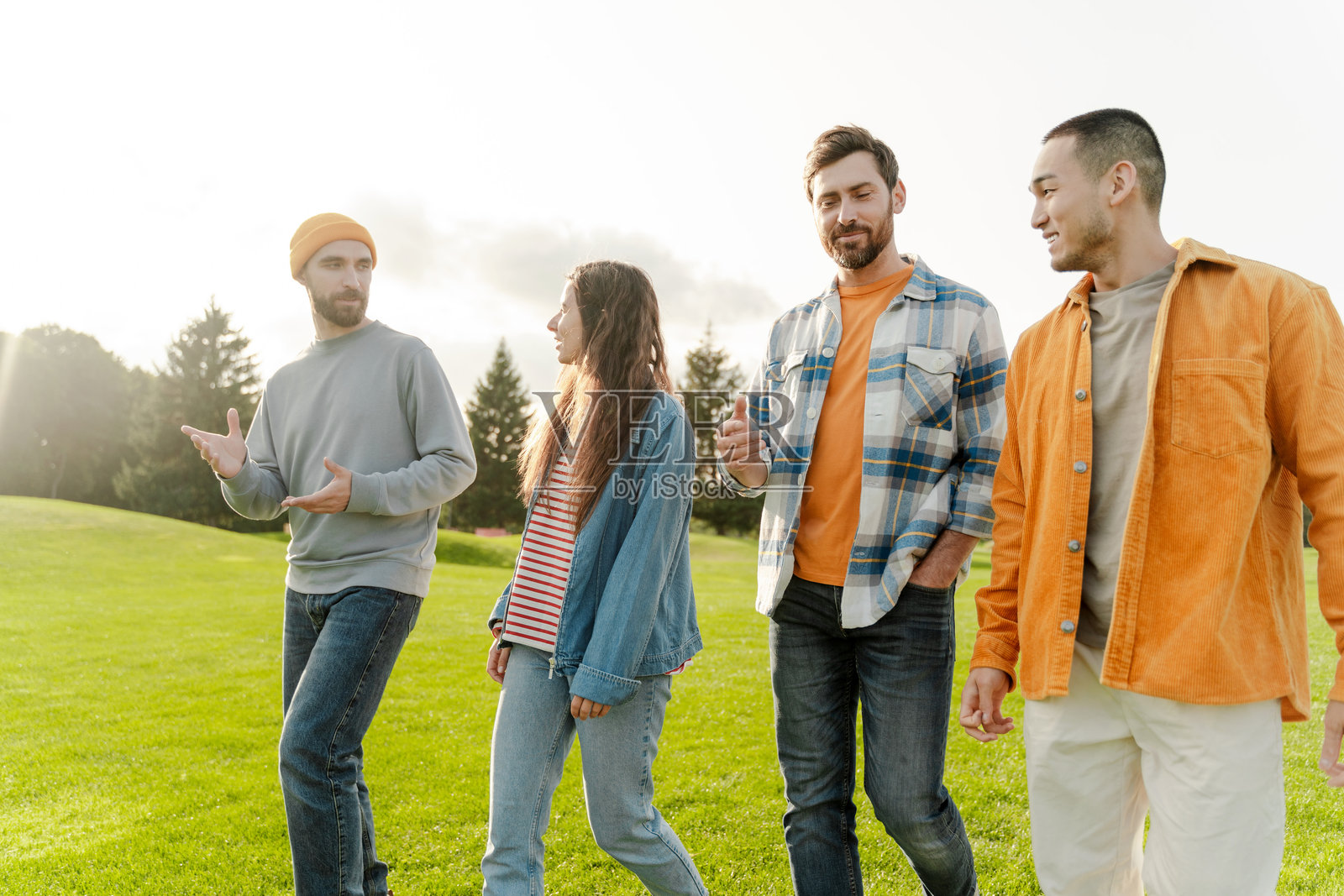 一群朋友在公园里一起走路聊天照片摄影图片