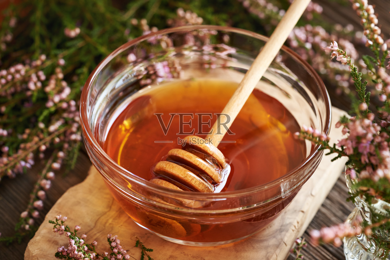 玻璃碗中的草本糖浆,搭配在森林中采摘的新鲜野生石楠花照片摄影图片
