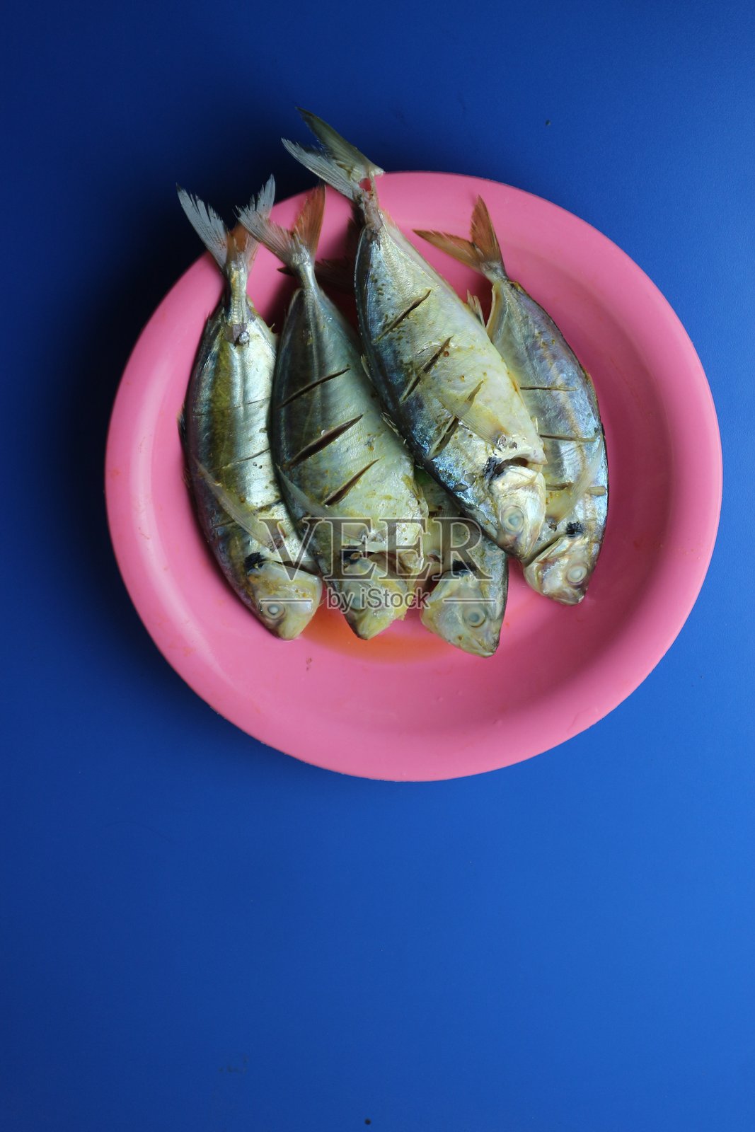 蓝色背景上的盘子里盛着生鱼片照片摄影图片