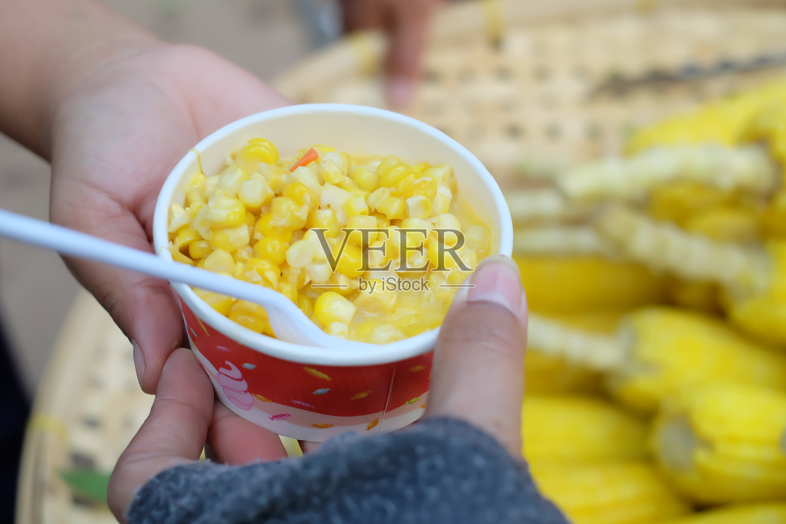 手握碗中的玉米照片摄影图片