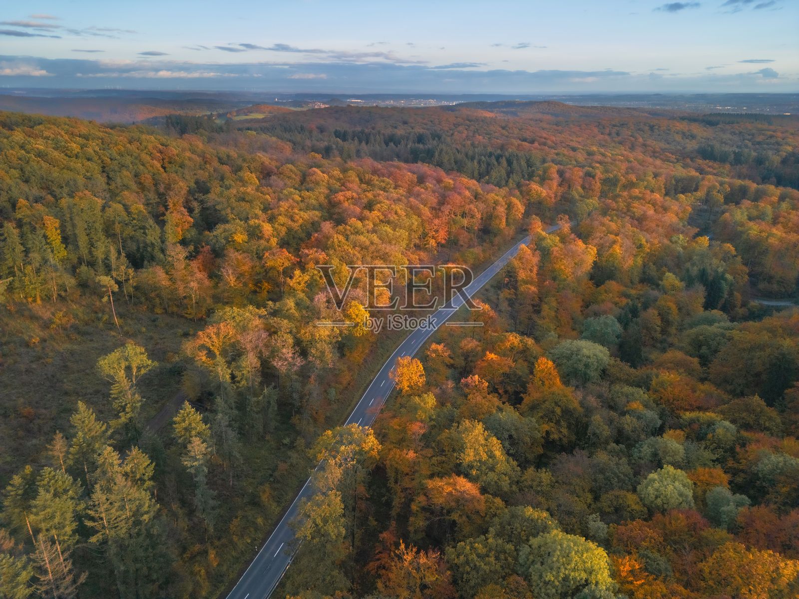 秋季森林中蜿蜒道路的鸟瞰图。照片摄影图片