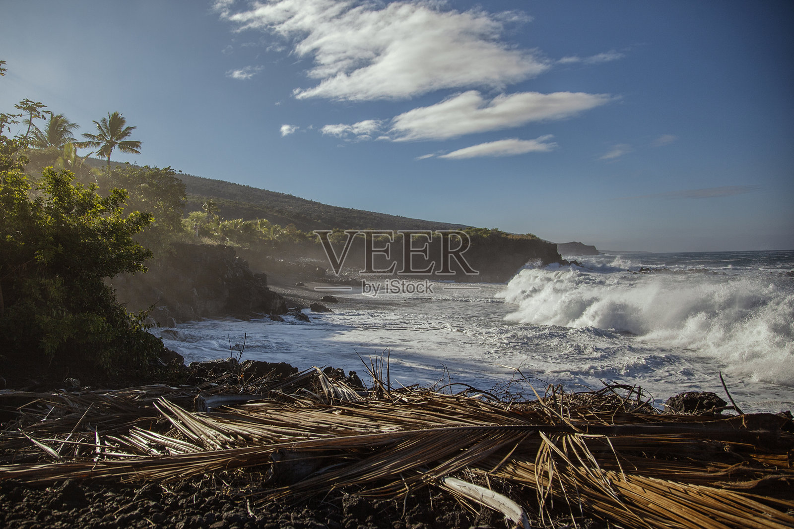 迷人的海浪在夏威夷大岛崎岖的海岸线上拍打,映衬着绚丽的天空。照片摄影图片