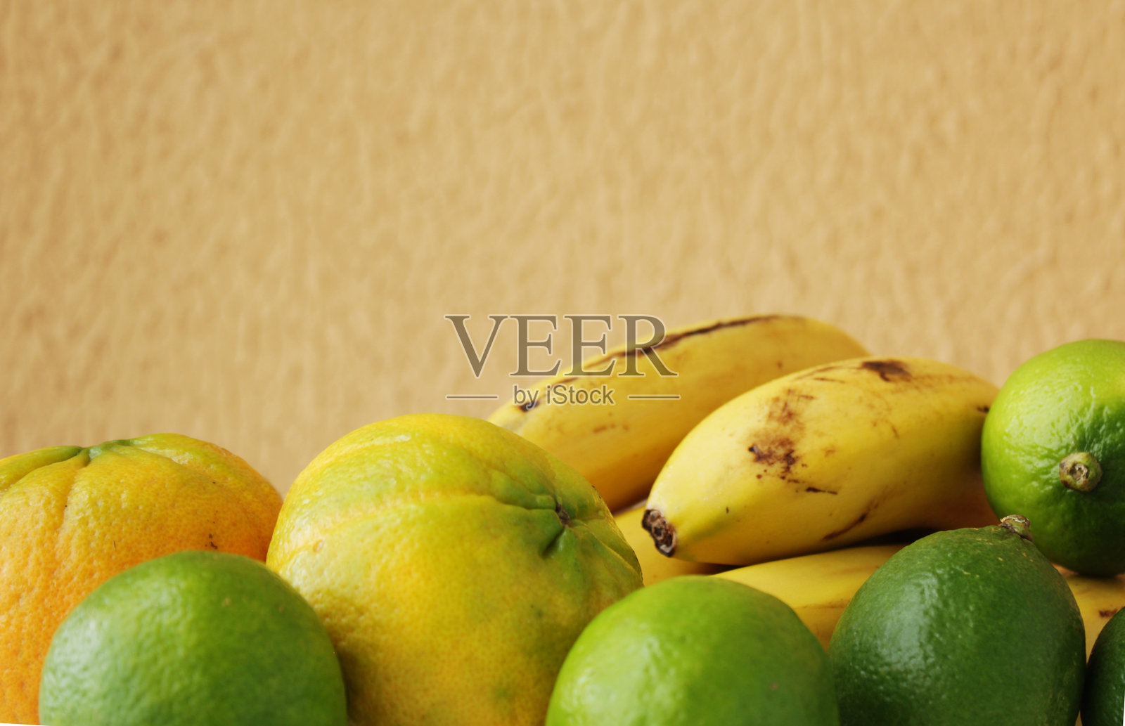 热带水果,包括香蕉、橙子和青柠。照片摄影图片