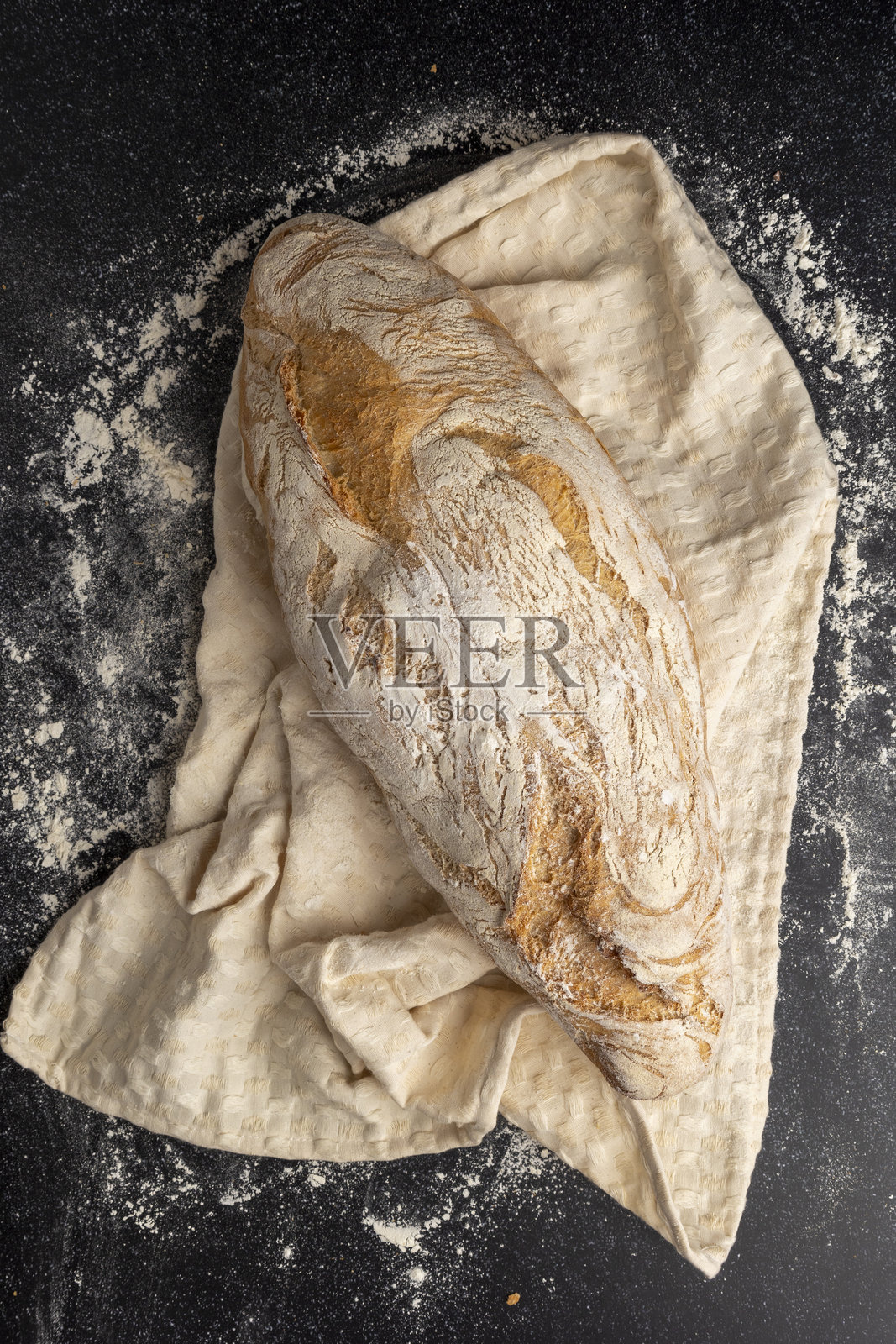 面包师傅手持撒满面粉的手工面包照片摄影图片