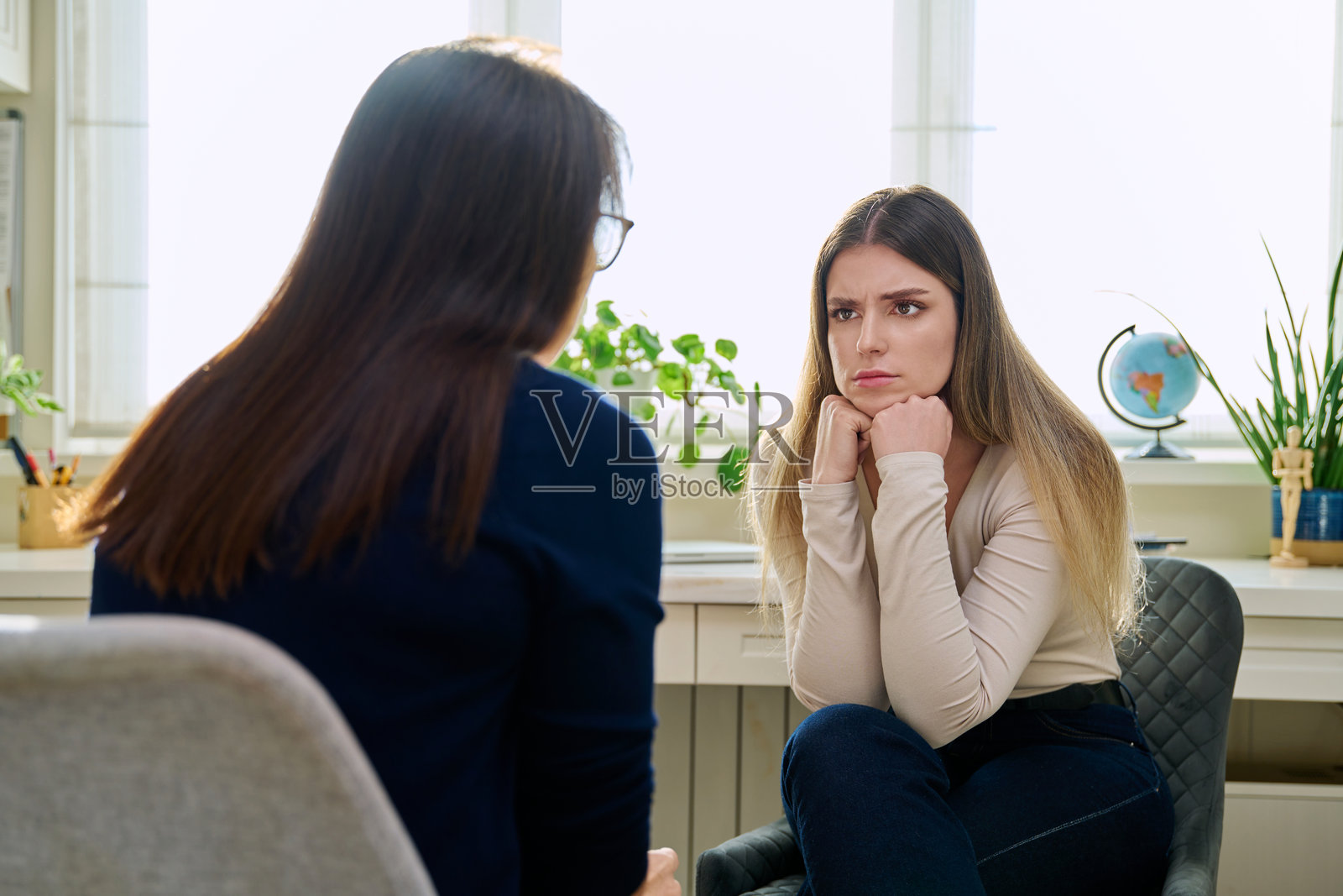 悲伤的不快乐年轻女性在与女性心理医生进行治疗照片摄影图片