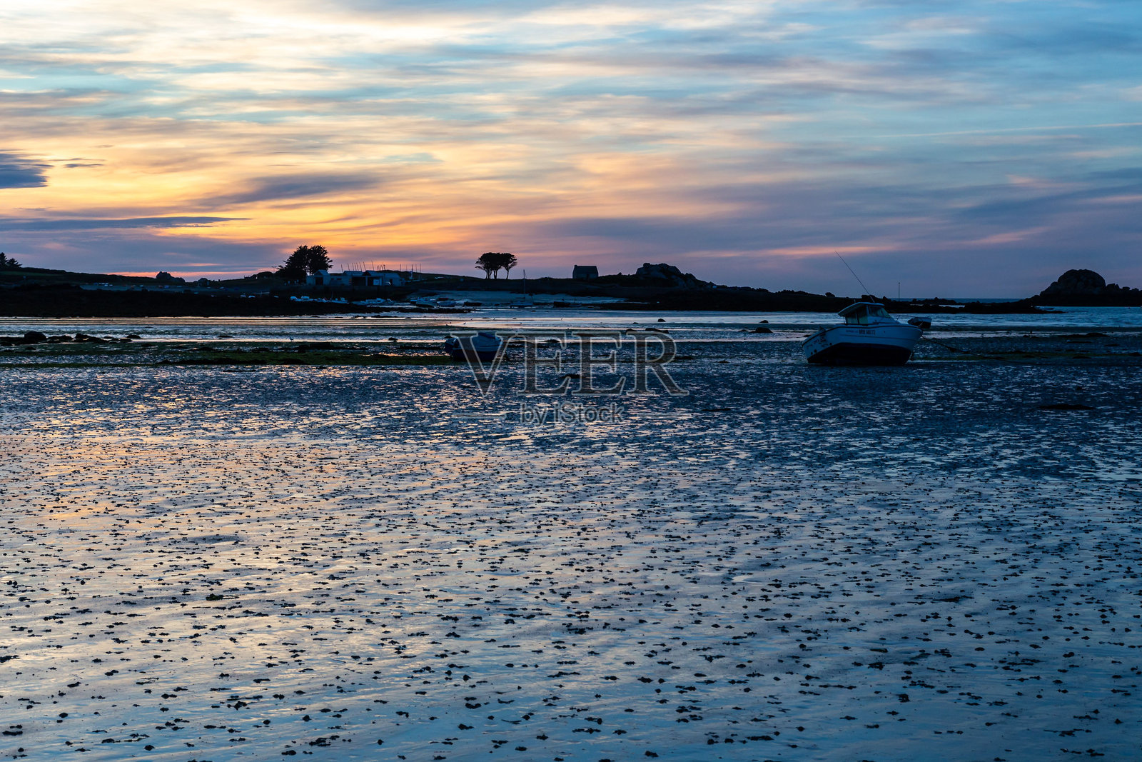 法国布列塔尼海岸宁静场景中的日落,温暖的光辉洒在海面上。照片摄影图片