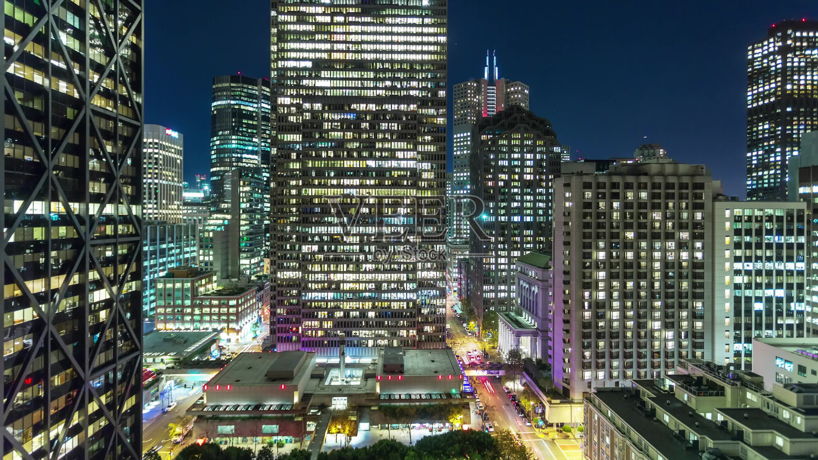 美国旧金山 - 2024年10月26日:夜晚城市景观,展示了灯火辉煌的摩天大楼和繁忙的市中心街道照片摄影图片