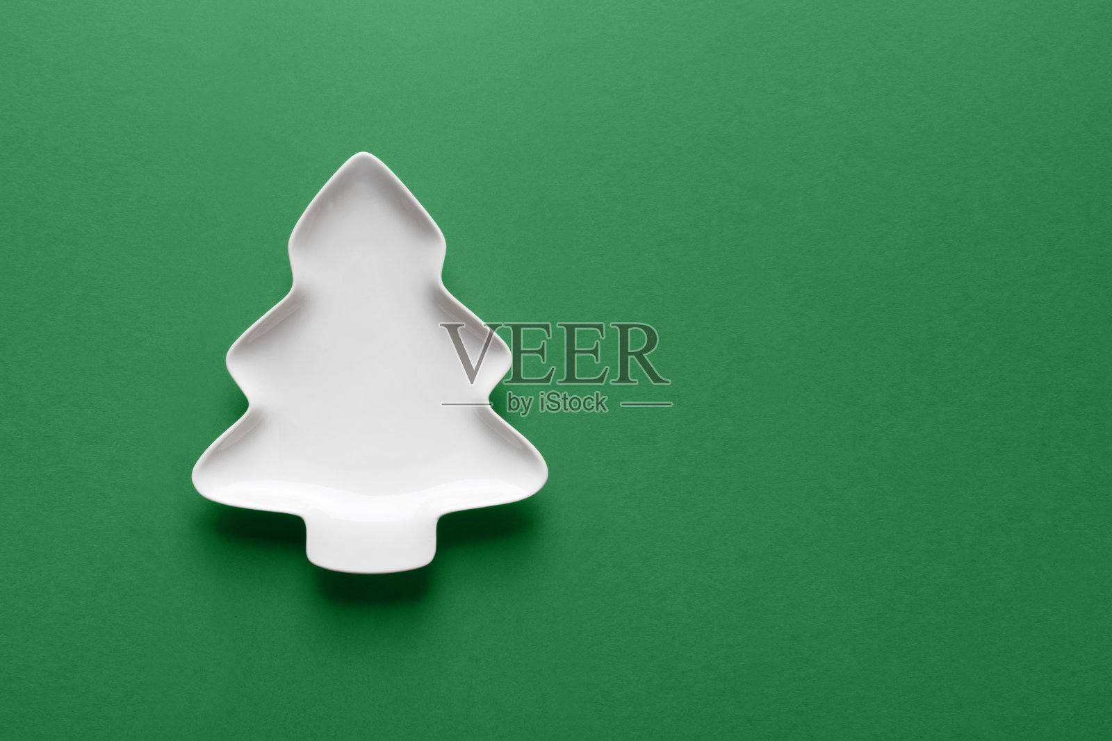 圣诞概念,白色盘子呈圣诞树形状。圣诞贺卡。照片摄影图片