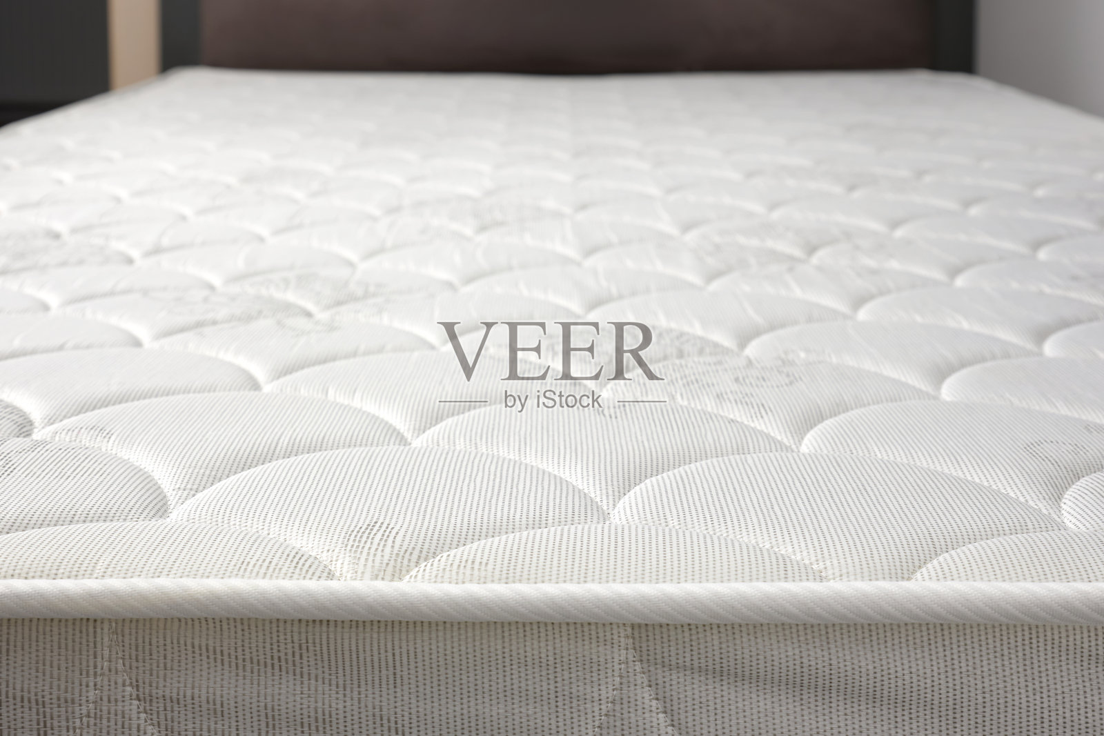 小公寓或房子里灰色床上的新白色床垫特写。照片摄影图片