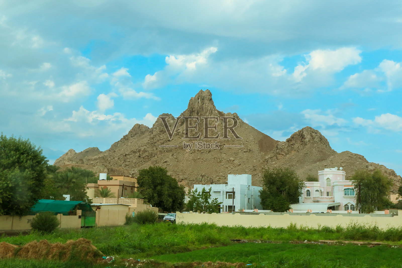 阿曼白天传统建筑前的岩石山脉美景照片摄影图片