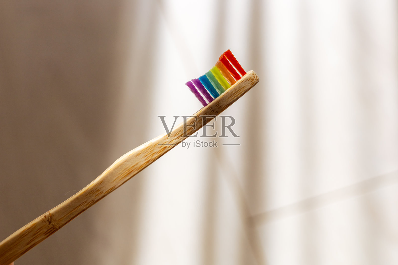 在明亮的浴室环境中,一把色彩斑斓的牙刷展现出彩虹般的微笑照片摄影图片