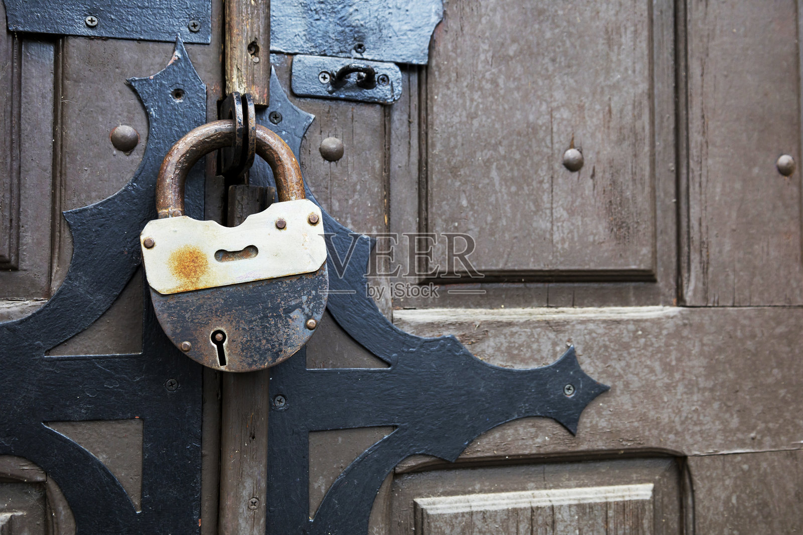 一个生锈的挂锁,中间有一个钥匙孔照片摄影图片