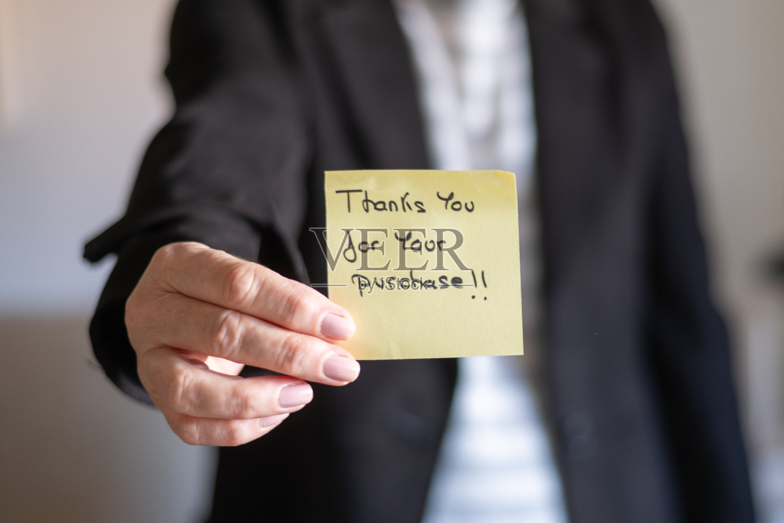 商务女性手持写有“感谢您的购买!”的便签纸照片摄影图片