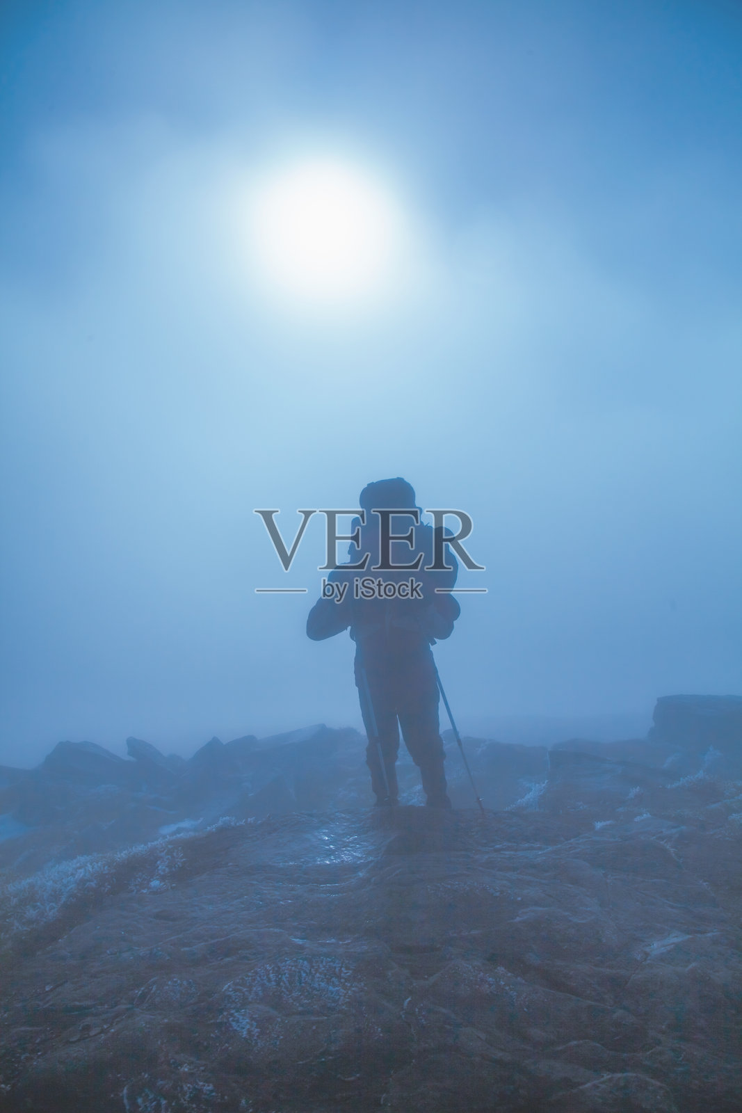 雾气和云层中的山顶徒步旅行者照片摄影图片