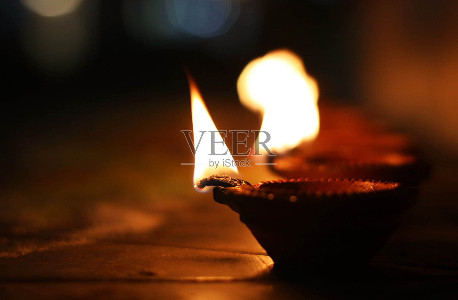 传统的陶土油灯,闪烁的火焰象征着希望、温暖和庆祝。非常适合像排灯节这样的节日,这些油灯营造出宁静和灵性的氛围。照片摄影图片