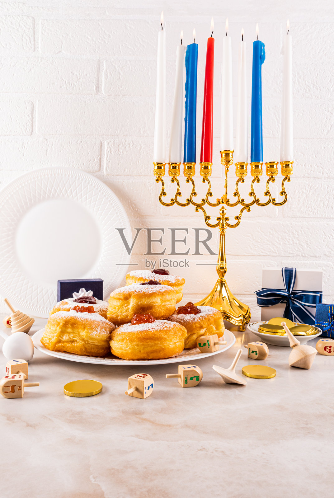 大理石台面上摆放着传统符号和美食,背景是白色砖墙。点燃的蜡烛在光明节的烛台上。垂直正面视图。静物。照片摄影图片
