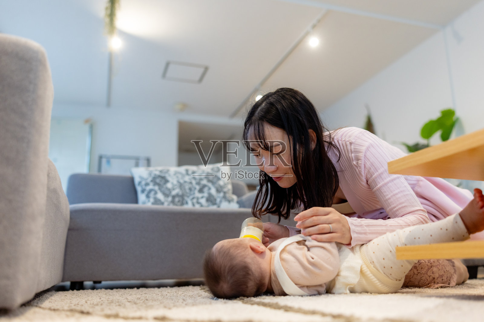 母亲在客厅里给宝宝喂奶照片摄影图片