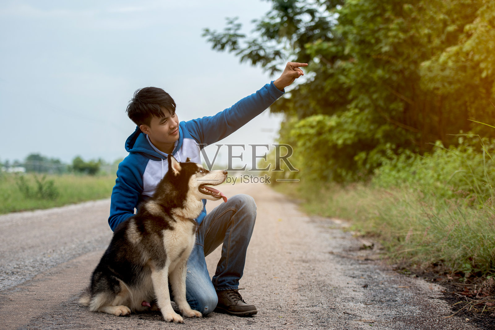 坐在路上的男人与狗照片摄影图片