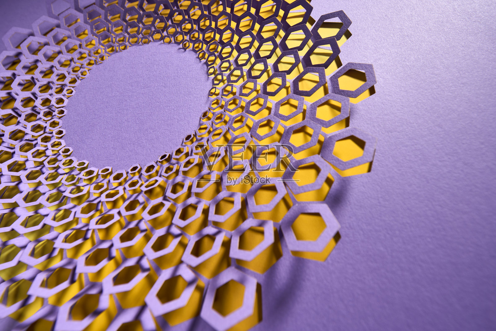 蜂窝灵感的纸雕设计,紫色背景上有分层的黄色高光照片摄影图片