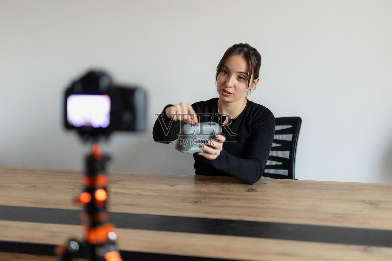 现代科技博客。积极的女性影响者在家中拍摄新耳机的视频评测,宣传新设备。照片摄影图片