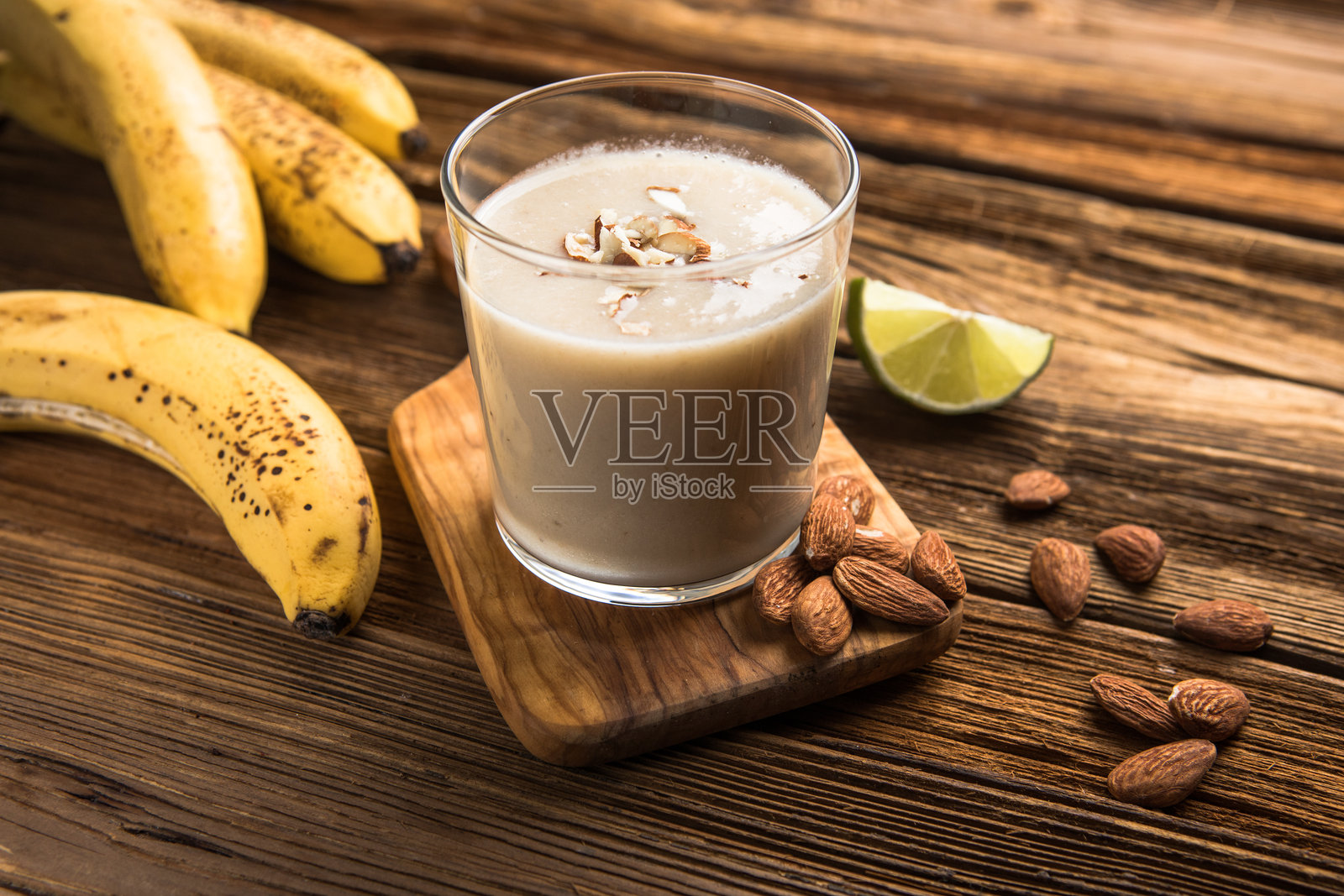 健康早餐。香蕉杏仁奶昔,加入肉桂、燕麦片和椰奶,装在玻璃罐中。照片摄影图片