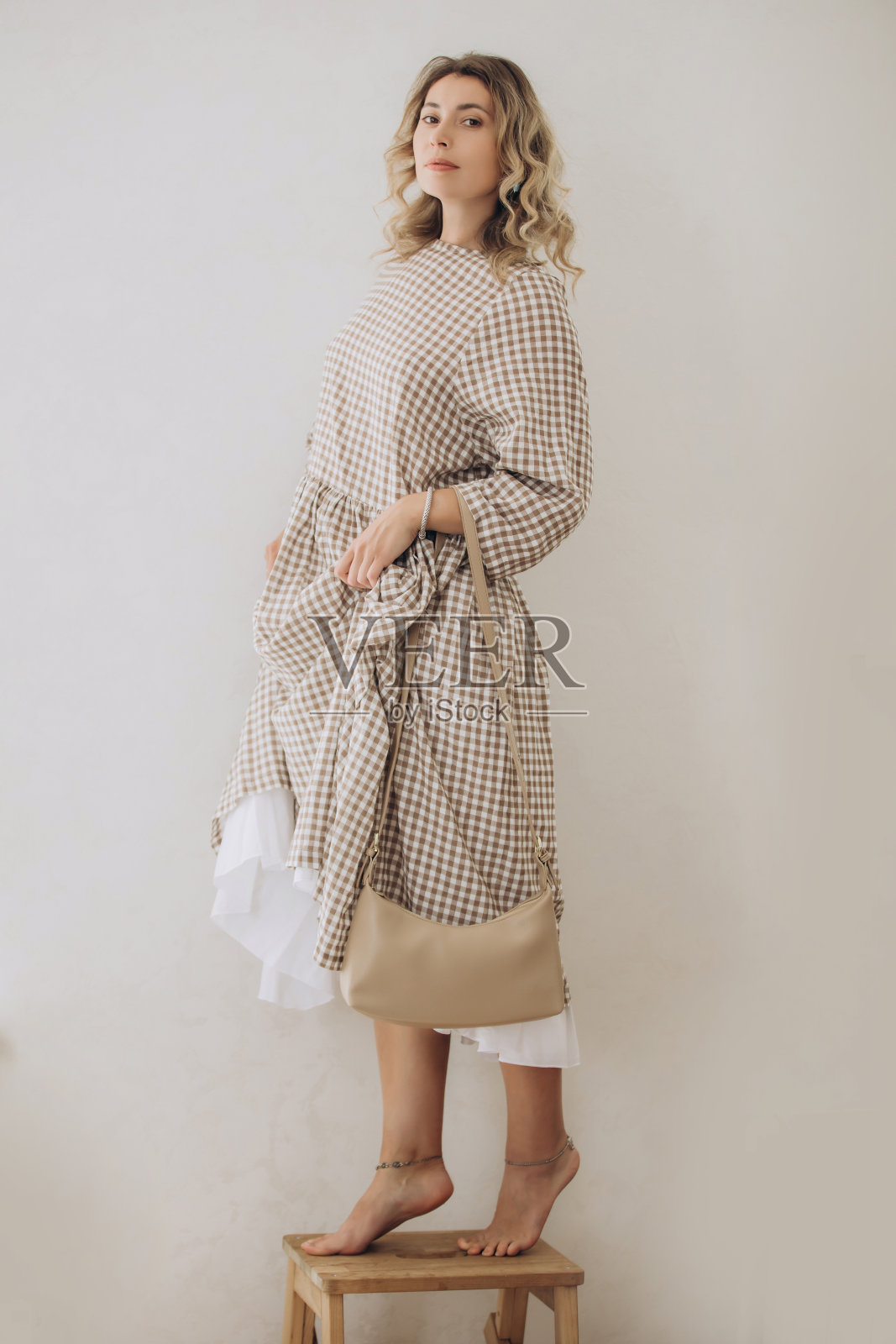 中年女性穿着格子图案服装,手提手袋照片摄影图片