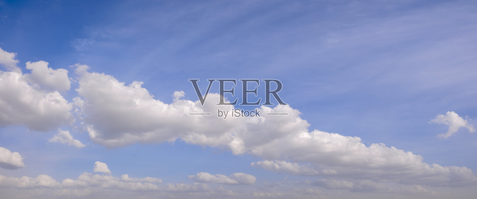 天空湛蓝,点缀着几朵白色蓬松的云朵,给人一种宁静和安详的感觉。照片摄影图片