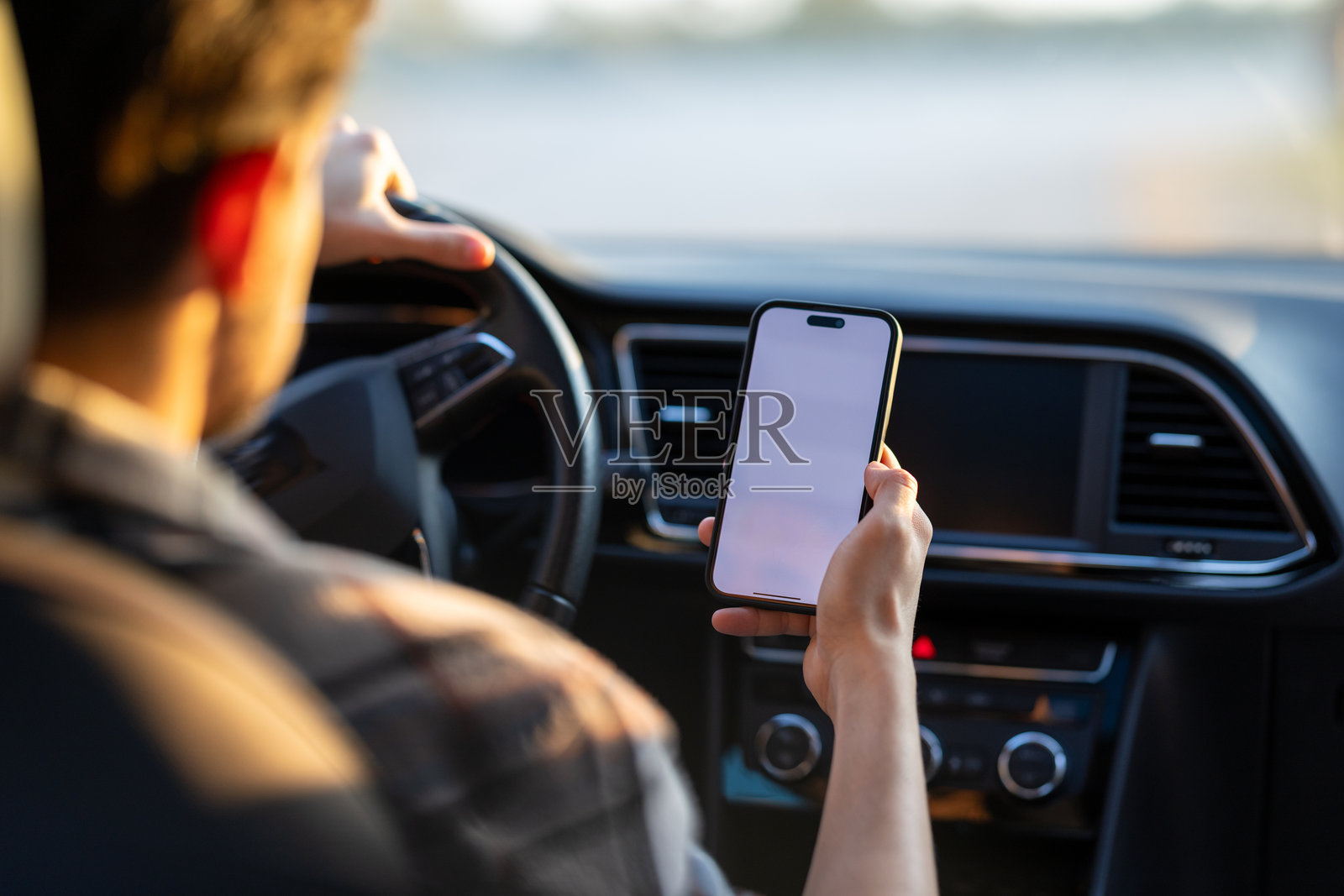 一名年轻男子在车内使用智能手机进行无接触支付,无需下车。照片摄影图片