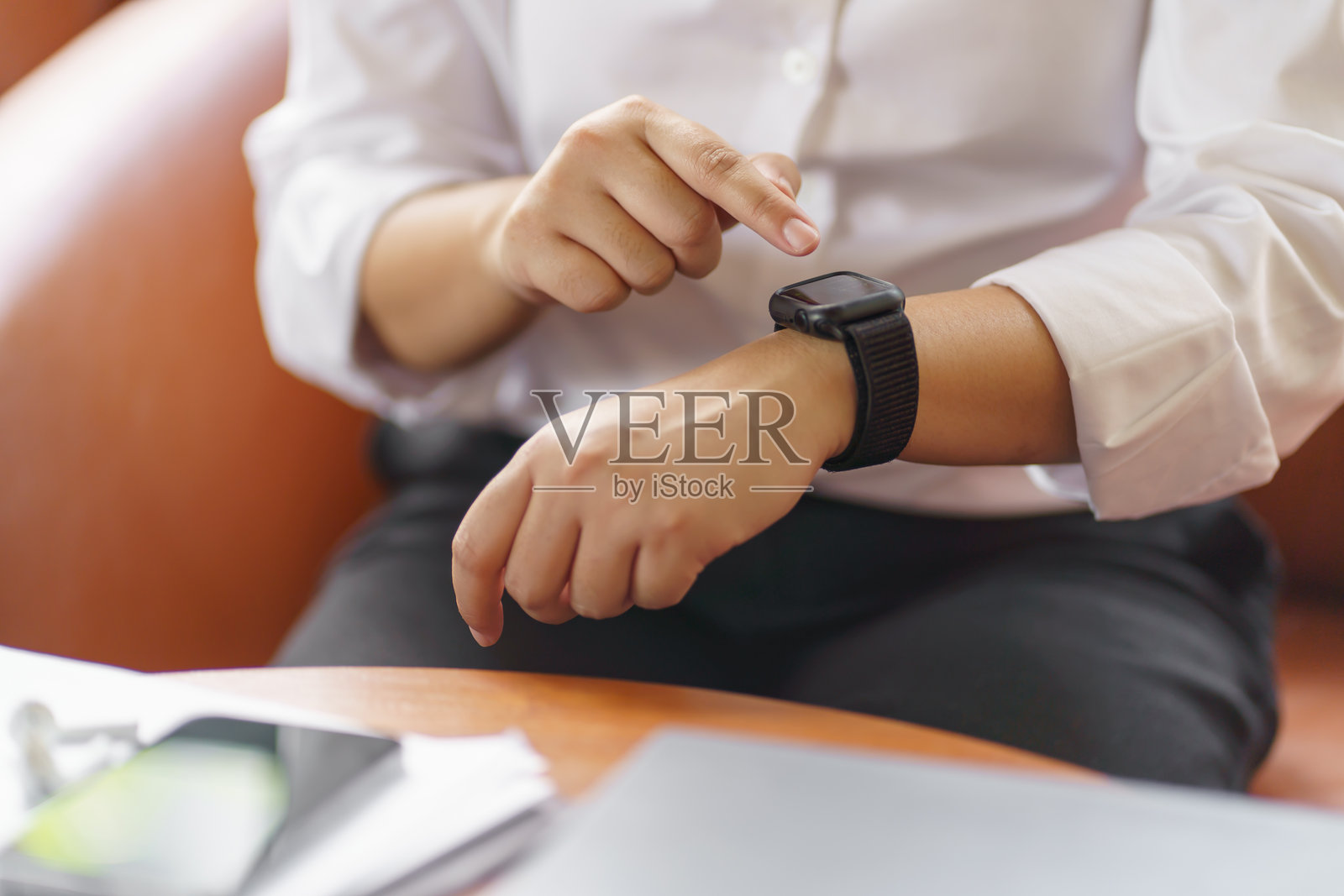 商务女性在办公室查看智能手表,在线连接科技设备。照片摄影图片