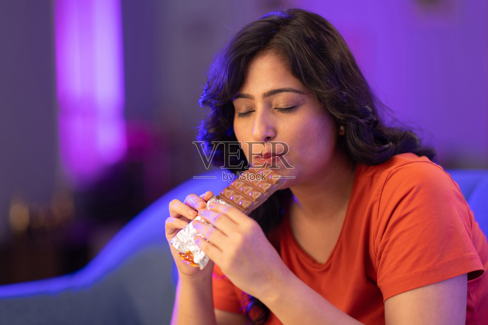 女人咬着一块巧克力棒的库存照片照片摄影图片