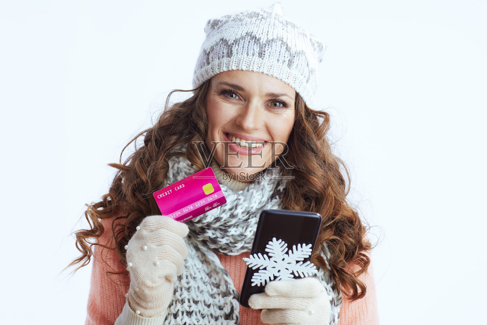 微笑的女性穿着毛衣、手套、帽子和围巾在网上购物照片摄影图片