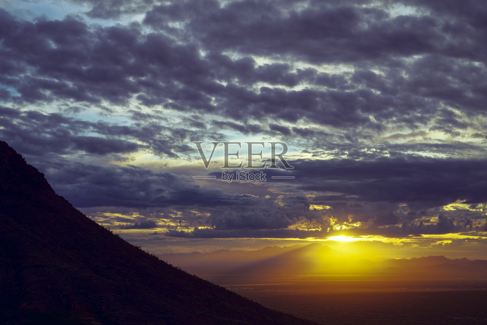 壮丽的日落映照在山脉上,伴随着戏剧性的云彩照片摄影图片