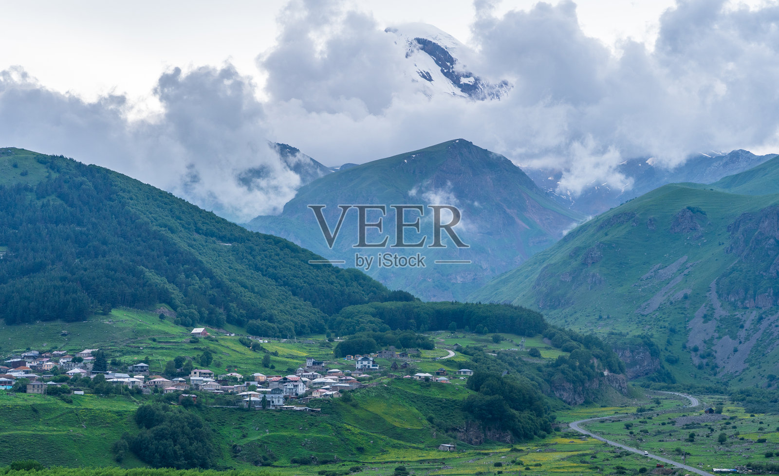 从草坡上俯瞰卡兹别克山脉和绿色山谷的全景照片摄影图片