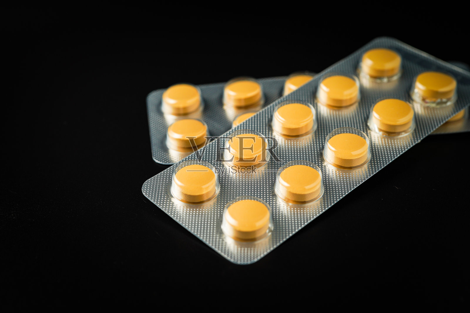 黑色背景上的棕黄色药片药物泡罩包装照片摄影图片