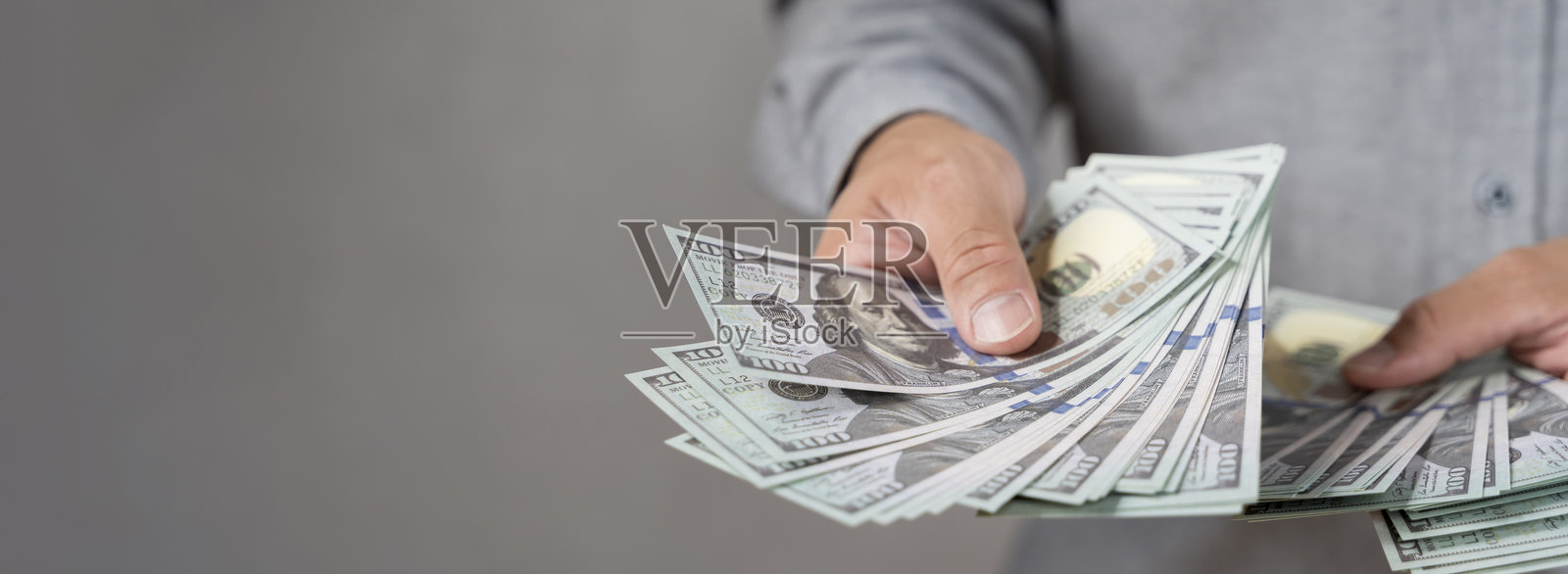 赠送一百美元。手中持有美国钞票,现金刺激赠送活动。照片摄影图片