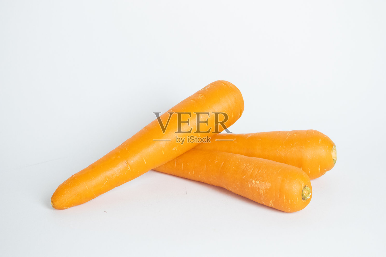 新鲜有机胡萝卜放在乡村风格的木盘上,背景为白色,孤立展示。照片摄影图片