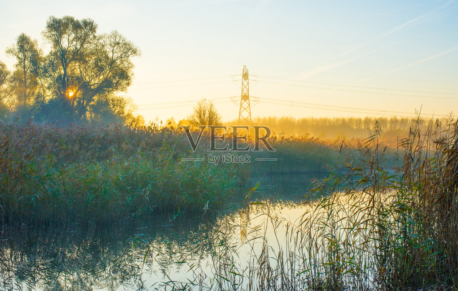 秋天雾蒙蒙的日出时分,湖边的景色照片摄影图片