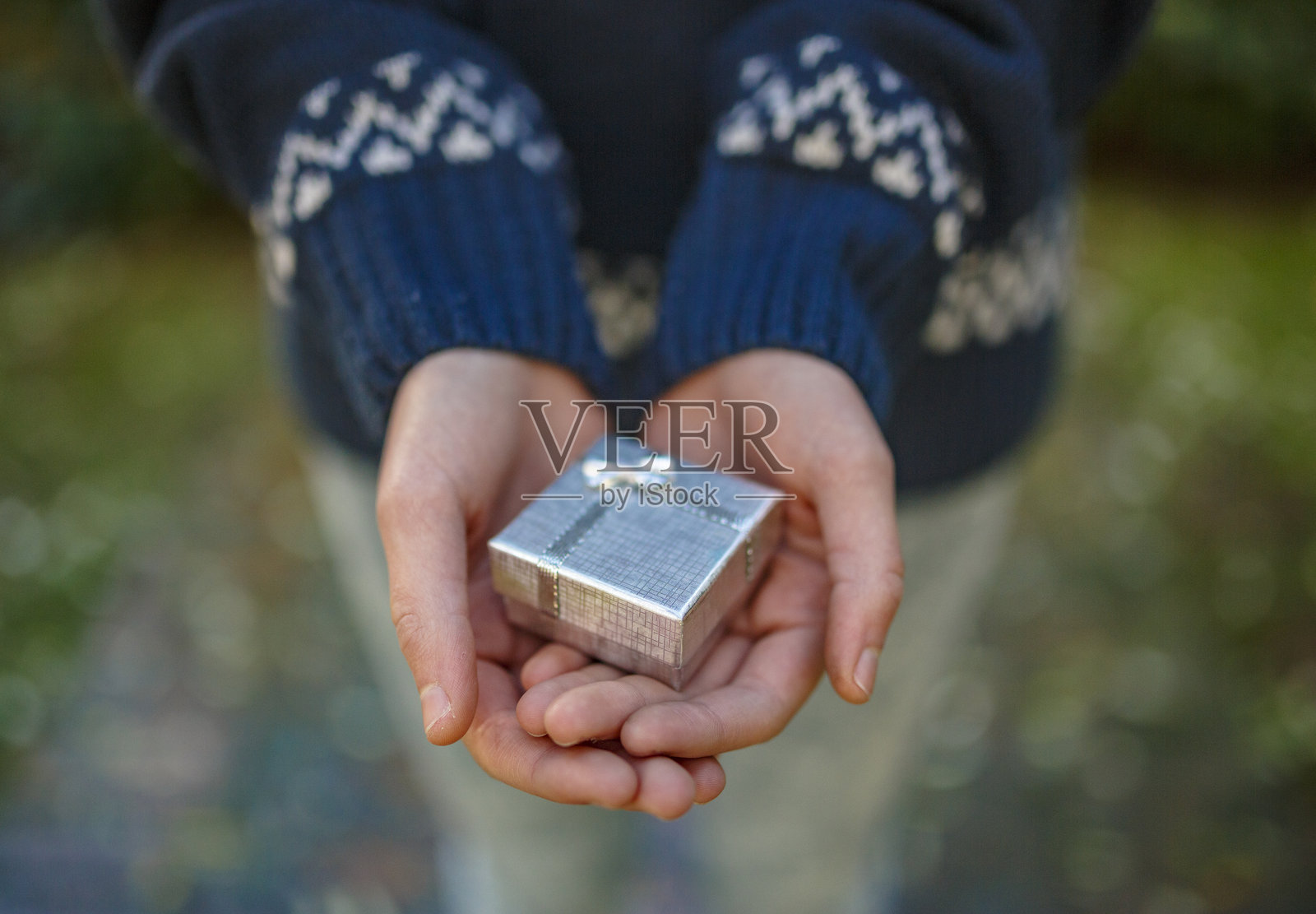 女人手中捧着一个小银色礼品盒照片摄影图片