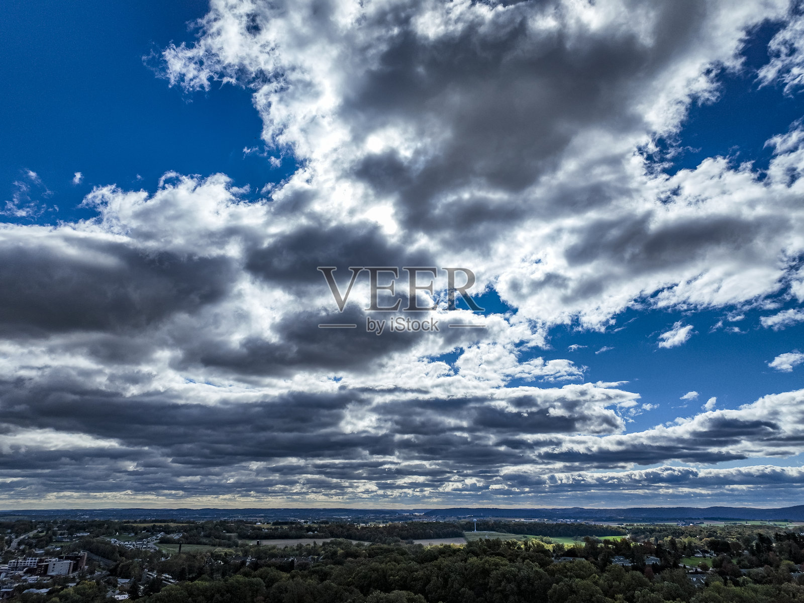 秋日下午,生机勃勃的云彩在林木景观上空的美丽天空景色照片摄影图片