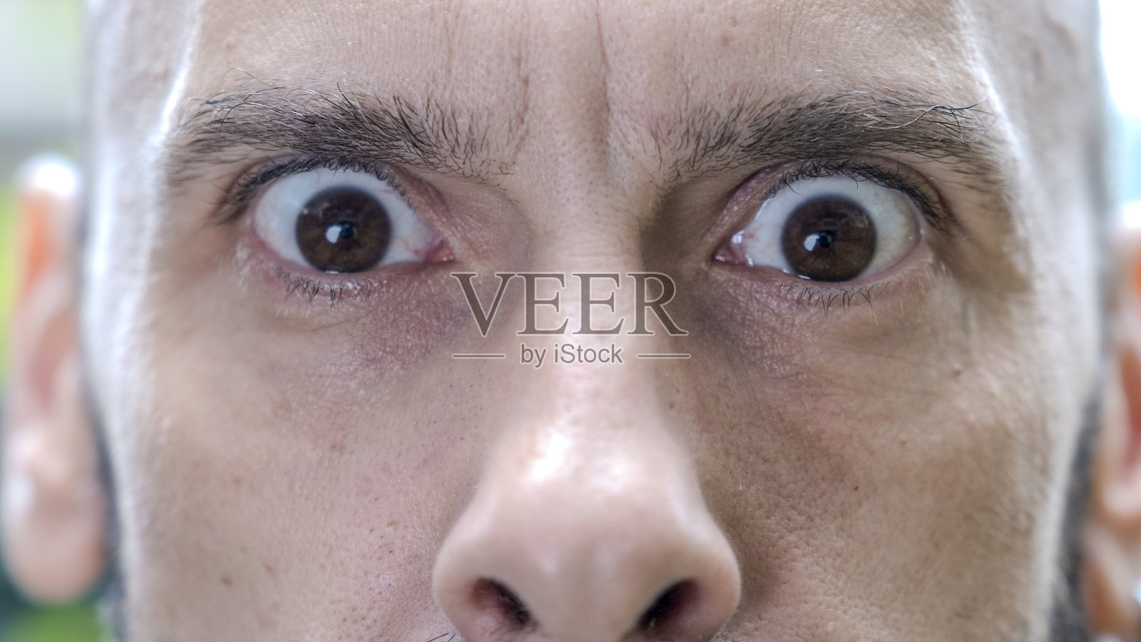 一位中年男子特写镜头,面部表情搞笑,正看着镜头。照片摄影图片