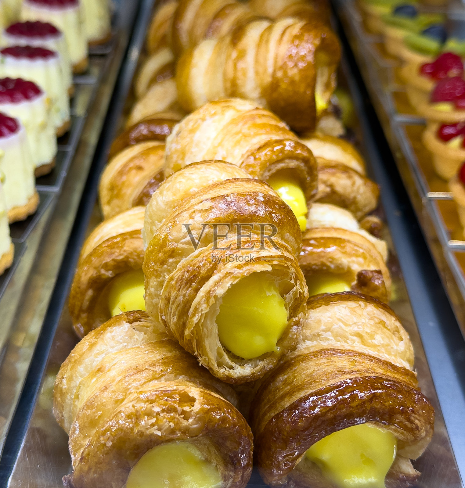 特写美味的卡农奇尼或奶油泡芙角,内填奶油。传统意大利糕点。黑色背景照片摄影图片