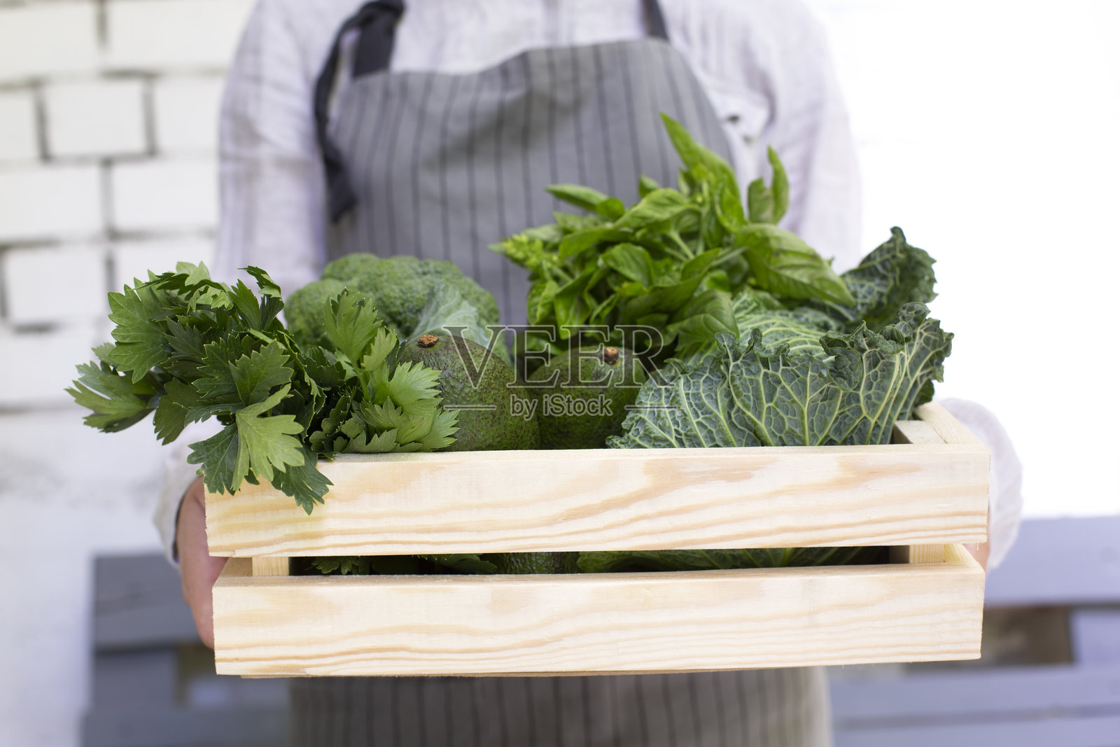 女性农民手持装有绿色农产品的生态木箱照片摄影图片