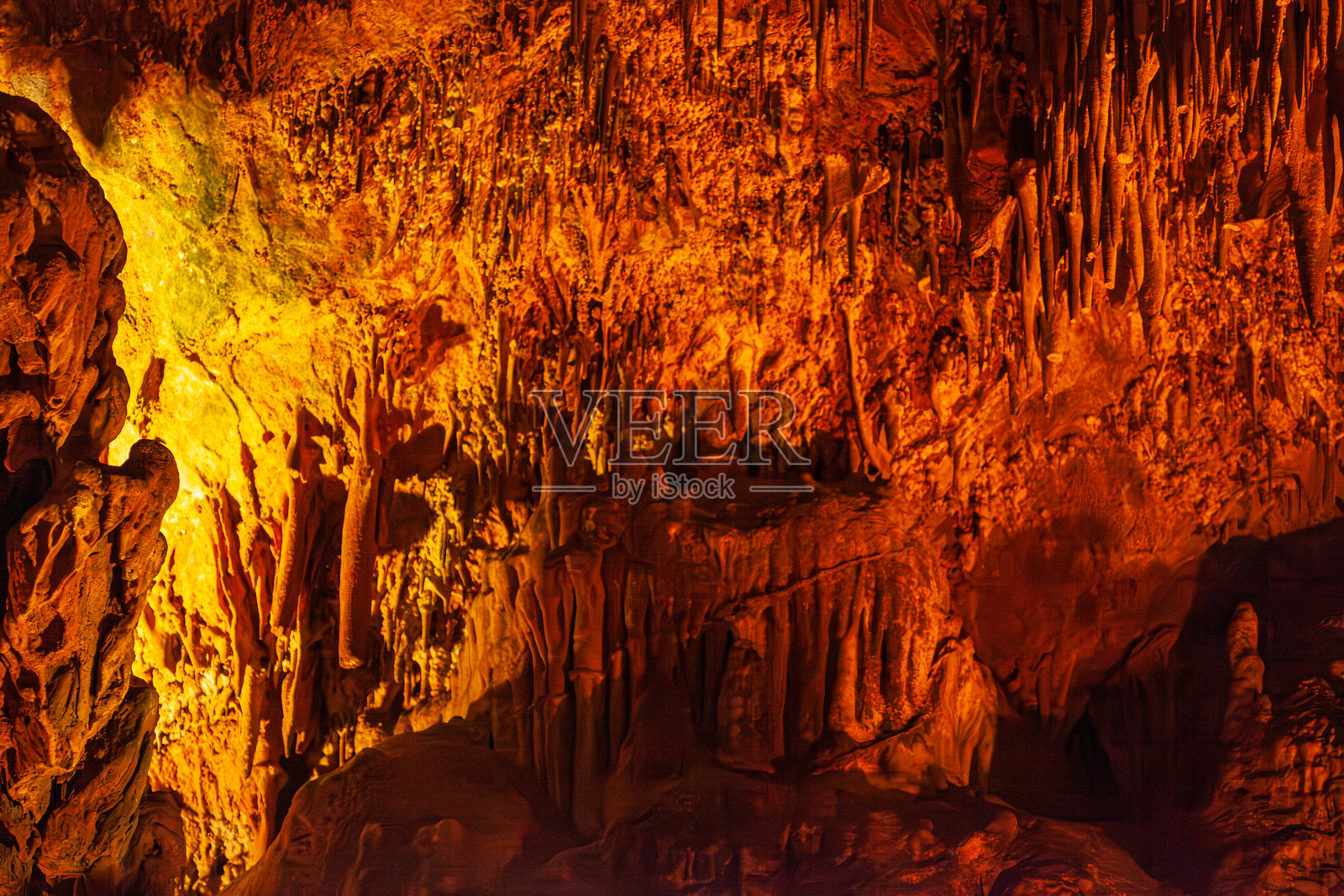 土耳其阿兰亚的达姆拉塔斯洞穴天花板上,尖锐的钟乳石形成的自然抽象纹理,棕橙色的石矿物质图案。照片摄影图片