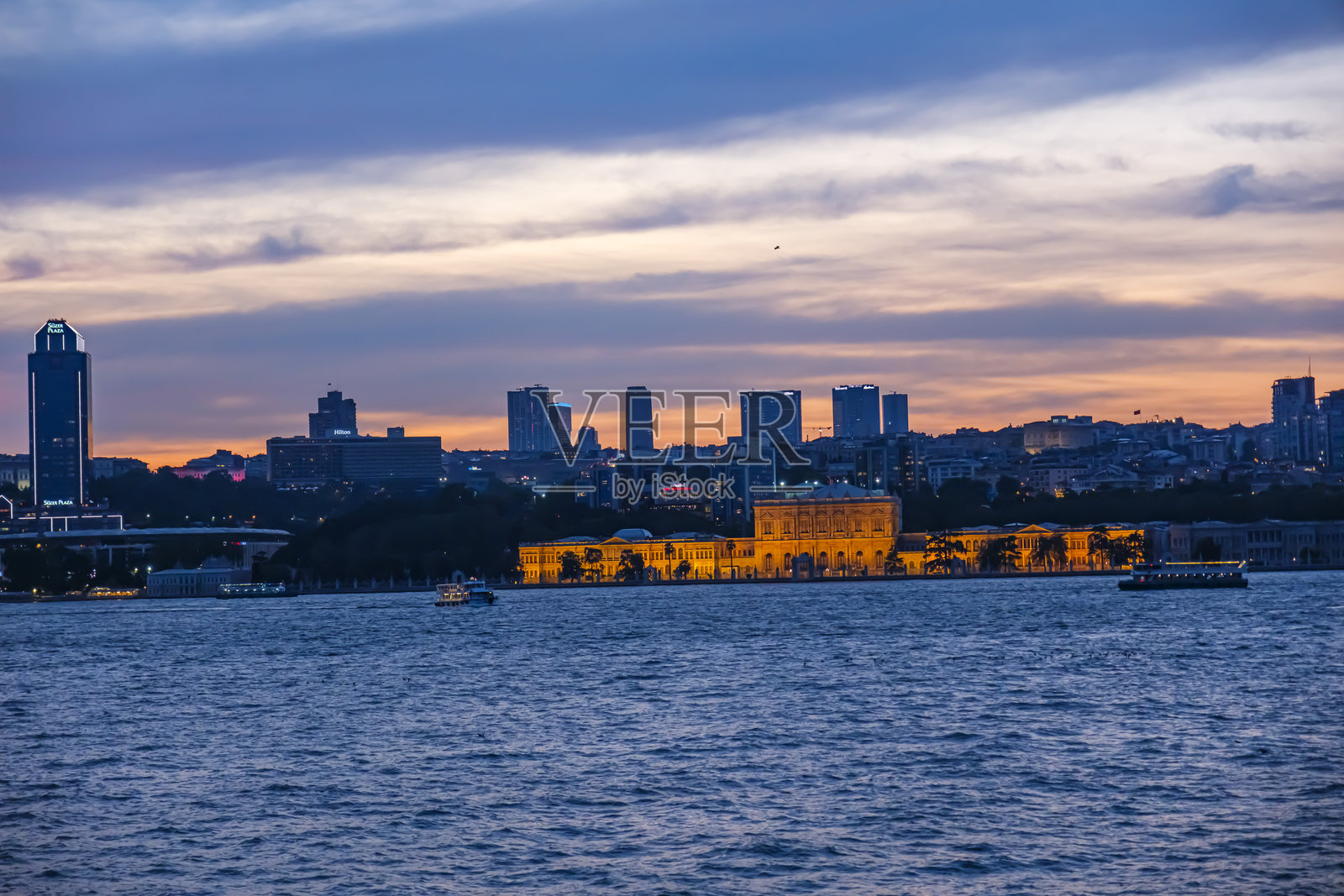 多尔马巴赫切宫的灯光建筑。伊斯坦布尔城市和摩天大楼的夜景。伊斯坦布尔博斯普鲁斯海峡的壮观全景夜景。照片摄影图片